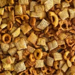 A golden, crispy homemade chex mix recipe , featuring cereals, pretzels, and nuts with a rich buttery coating